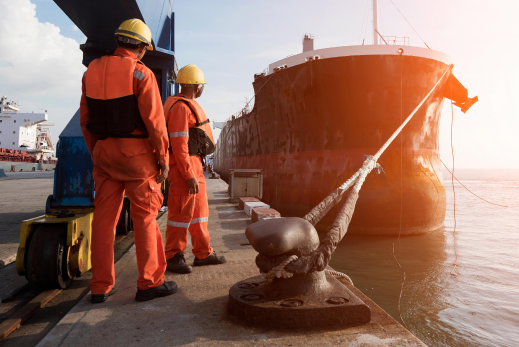 ghlcis employee standing next to cargo ship to untie its rope to start delivery journey
